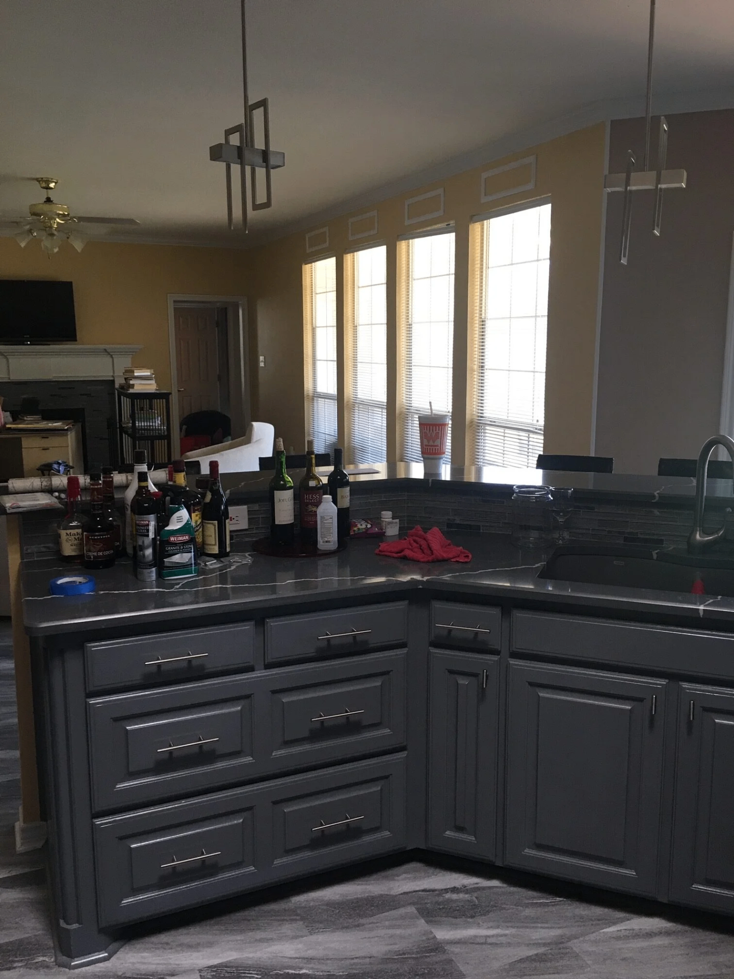 Kitchen with dark gray cabinets and quartz waterfall countertop