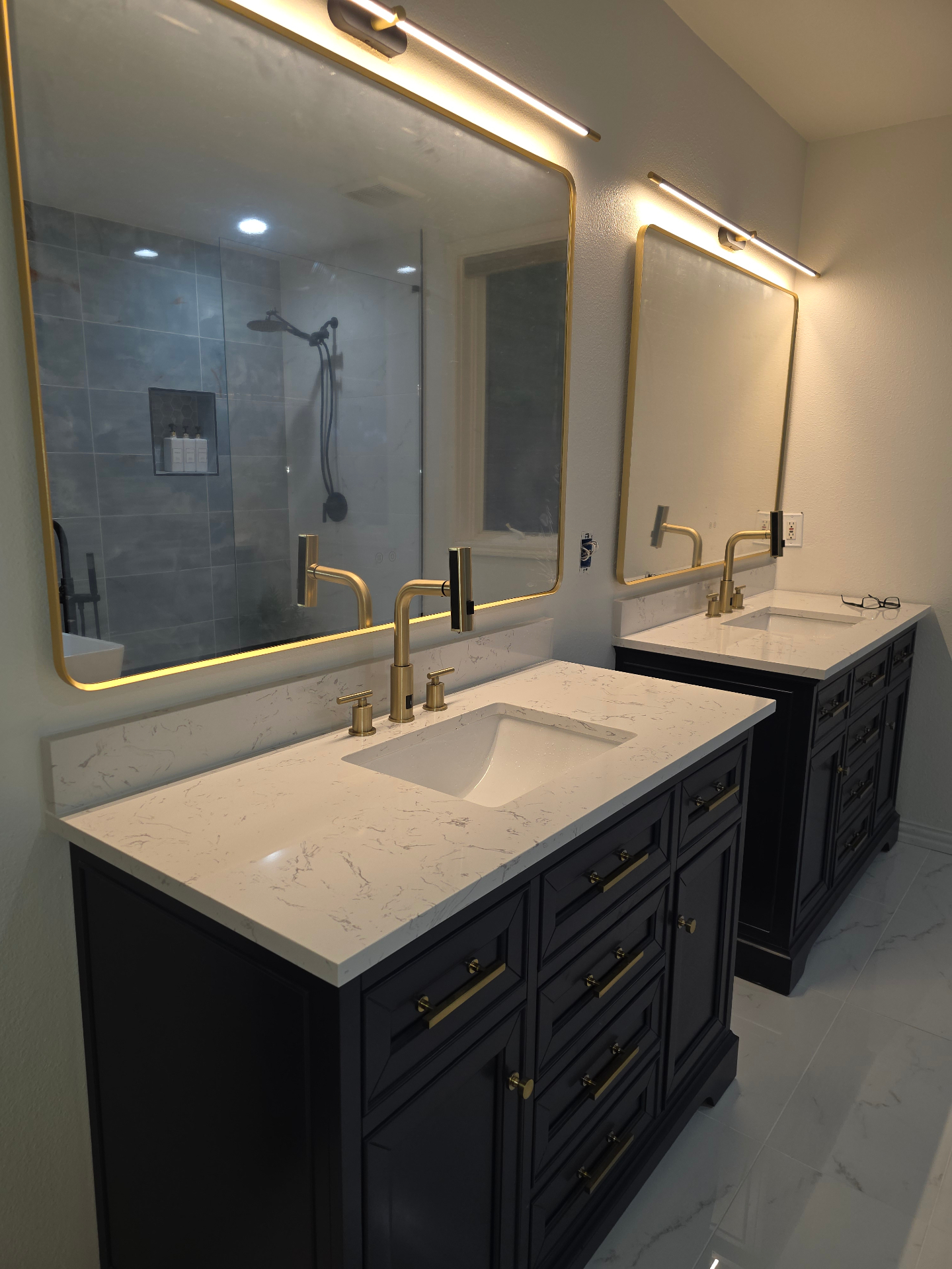 Double vanity bathroom with brass fixtures and marble quartz countertops