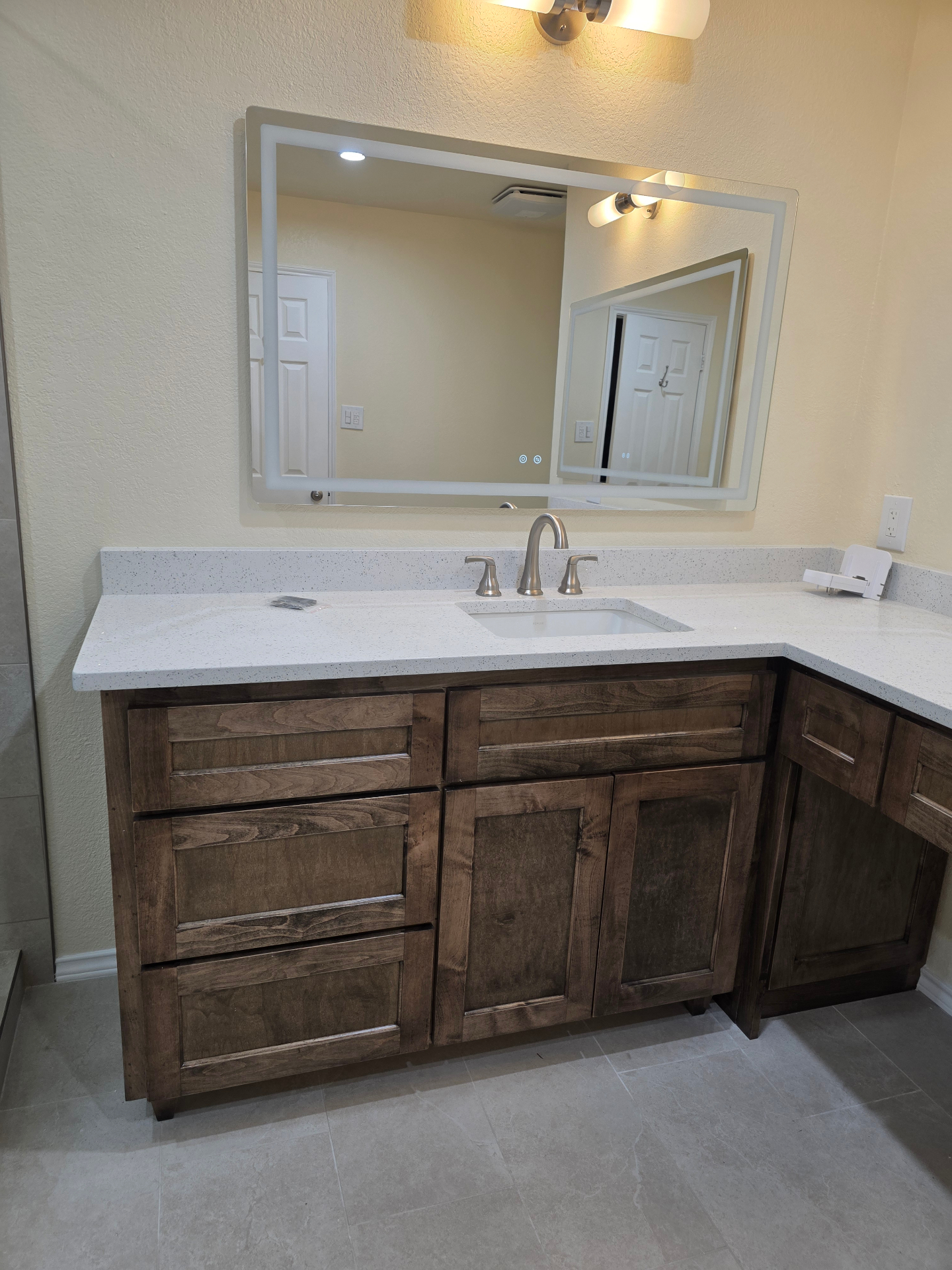 Bathroom vanity with quartz countertop and dark wood cabinets