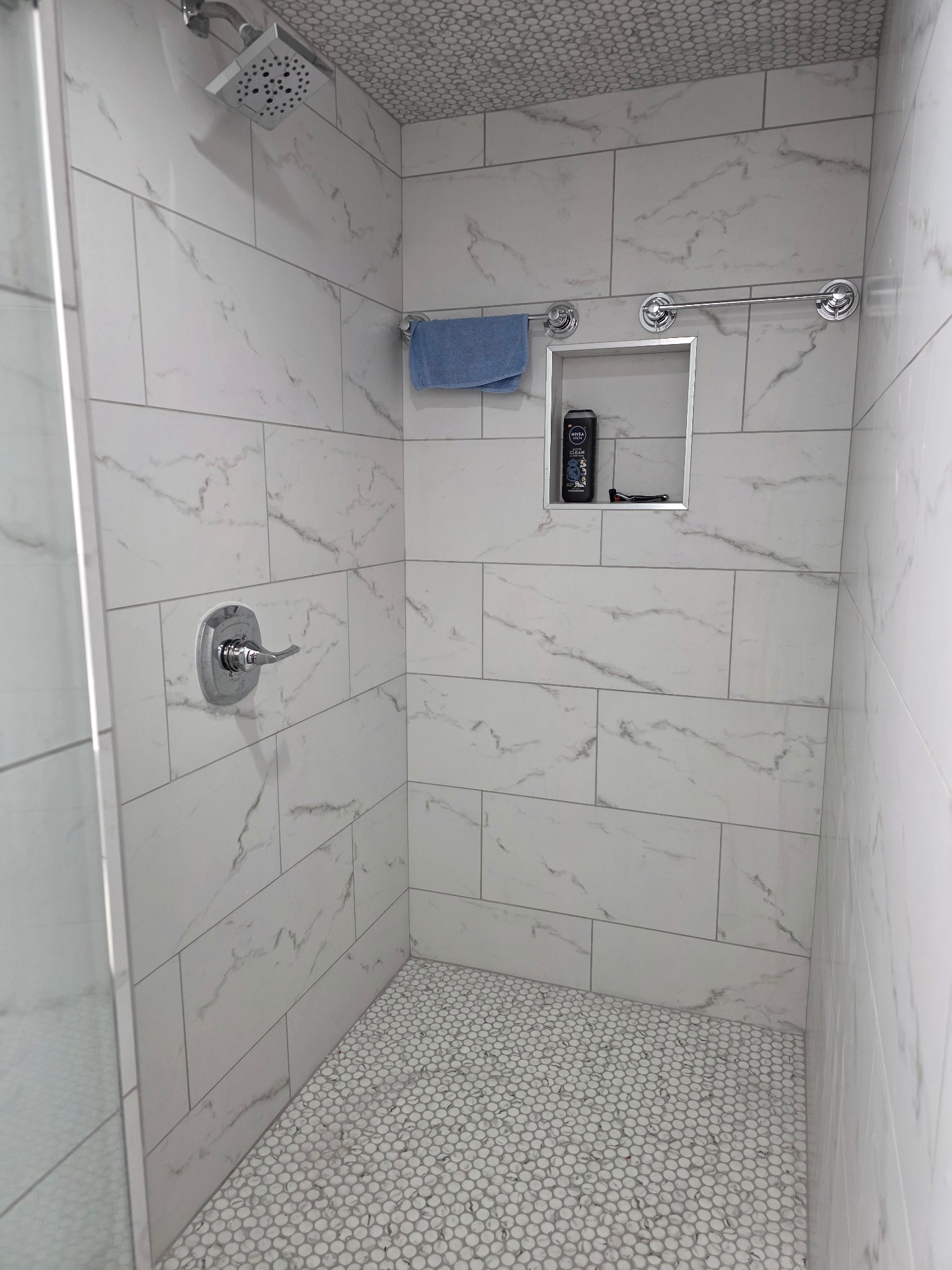 Marble tile walk-in shower with penny floor