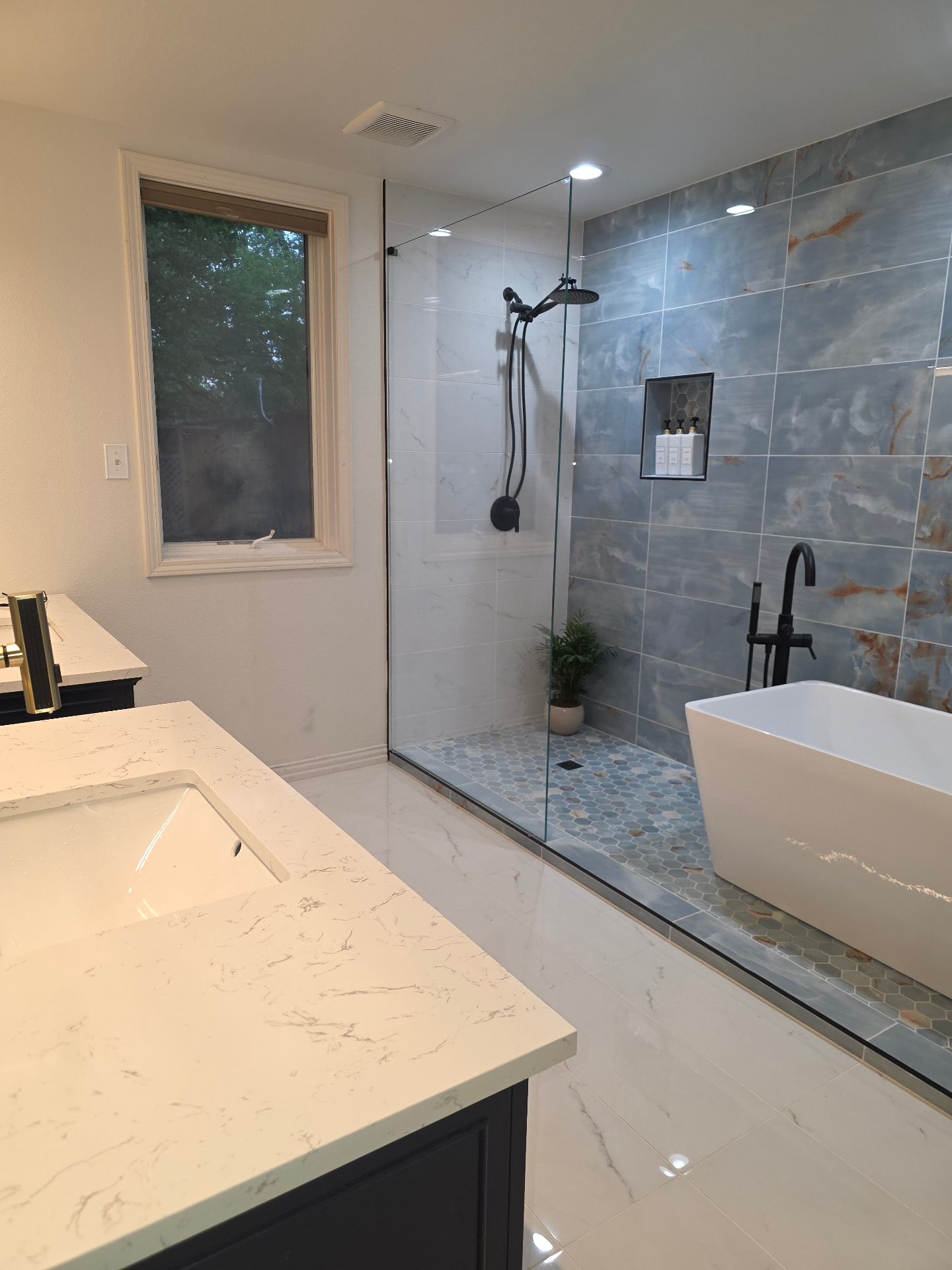 Master bathroom with freestanding tub and blue tile shower